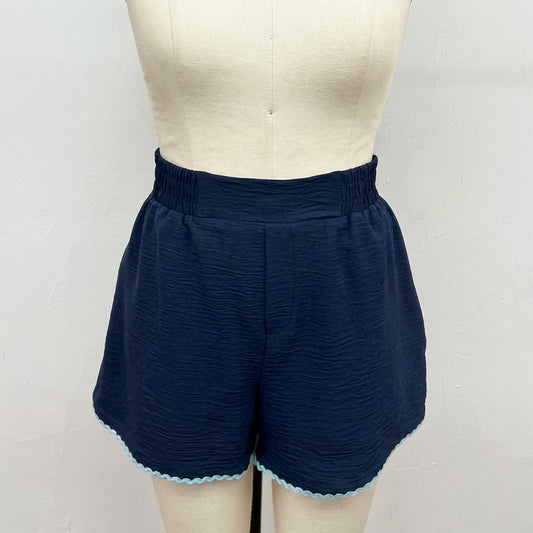 Navy blue shorts with wavy hem on a mannequin.