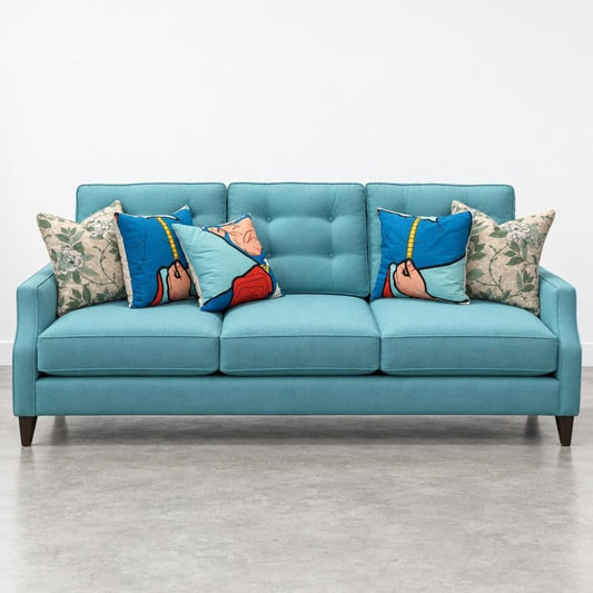 Blue sofa with superhero and floral pillows.