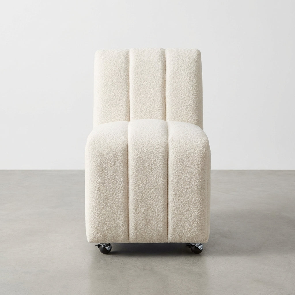 White cushioned chair on wheels, minimalistic design.