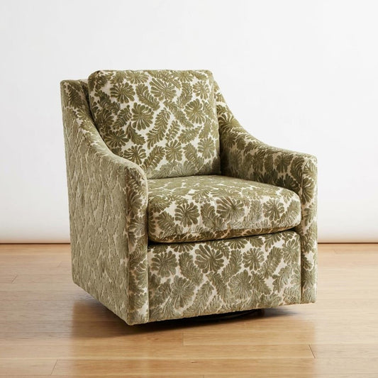 Green floral patterned armchair on wooden floor.