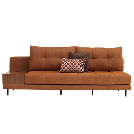 Modern orange sofa with pillows and an attached wooden side table.
