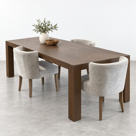Wooden dining table with three chairs and two vases.