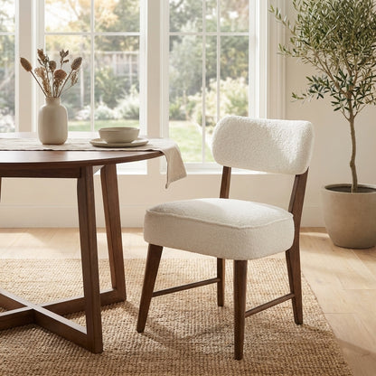 White cushioned chair with wooden legs on a white background.