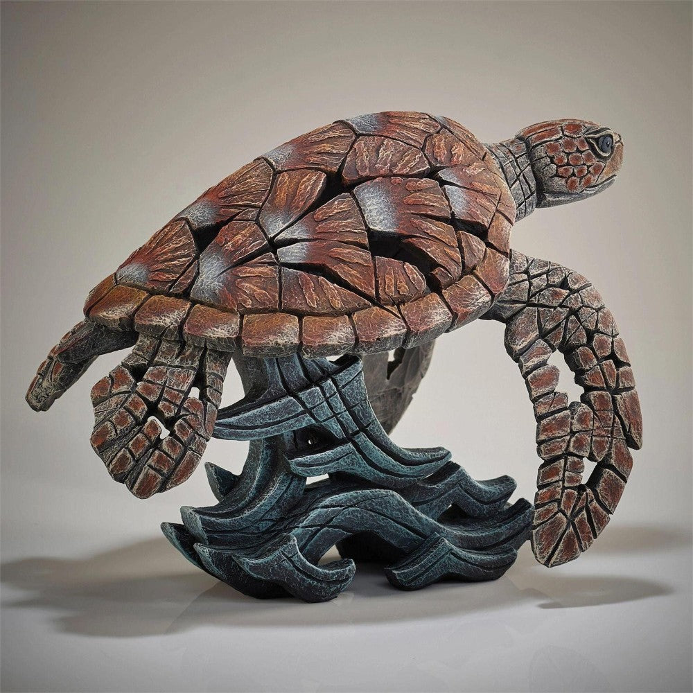 Sculpted sea turtle with textured shell and detailed fins on a wave base.