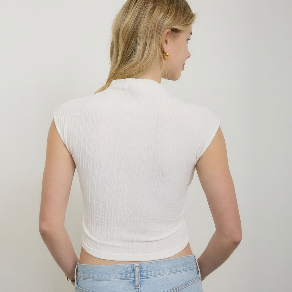 Woman in white top and jeans, facing away.