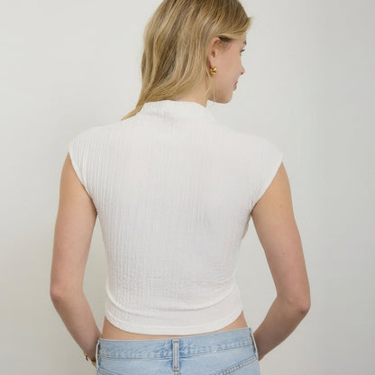 Woman in white top and jeans, facing away.