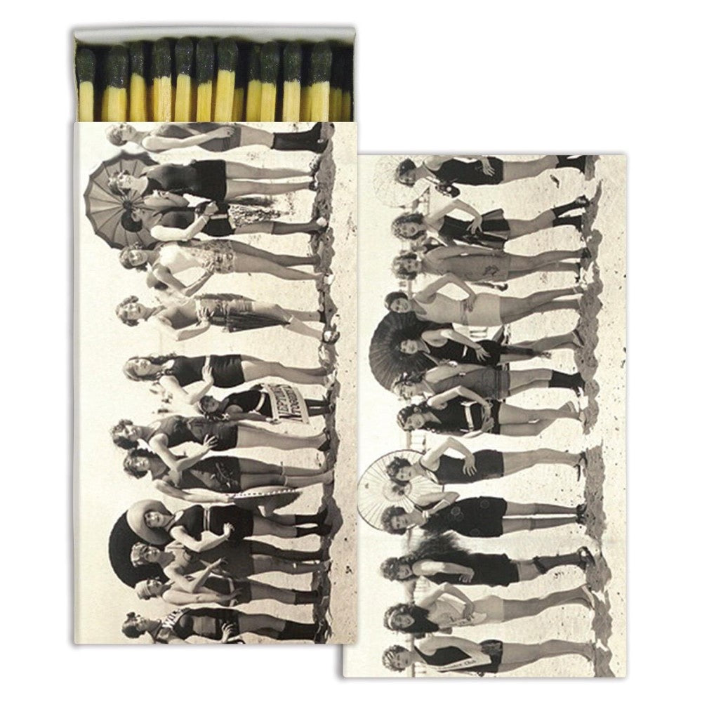 Vintage beachgoers with umbrellas on a matchbox cover.