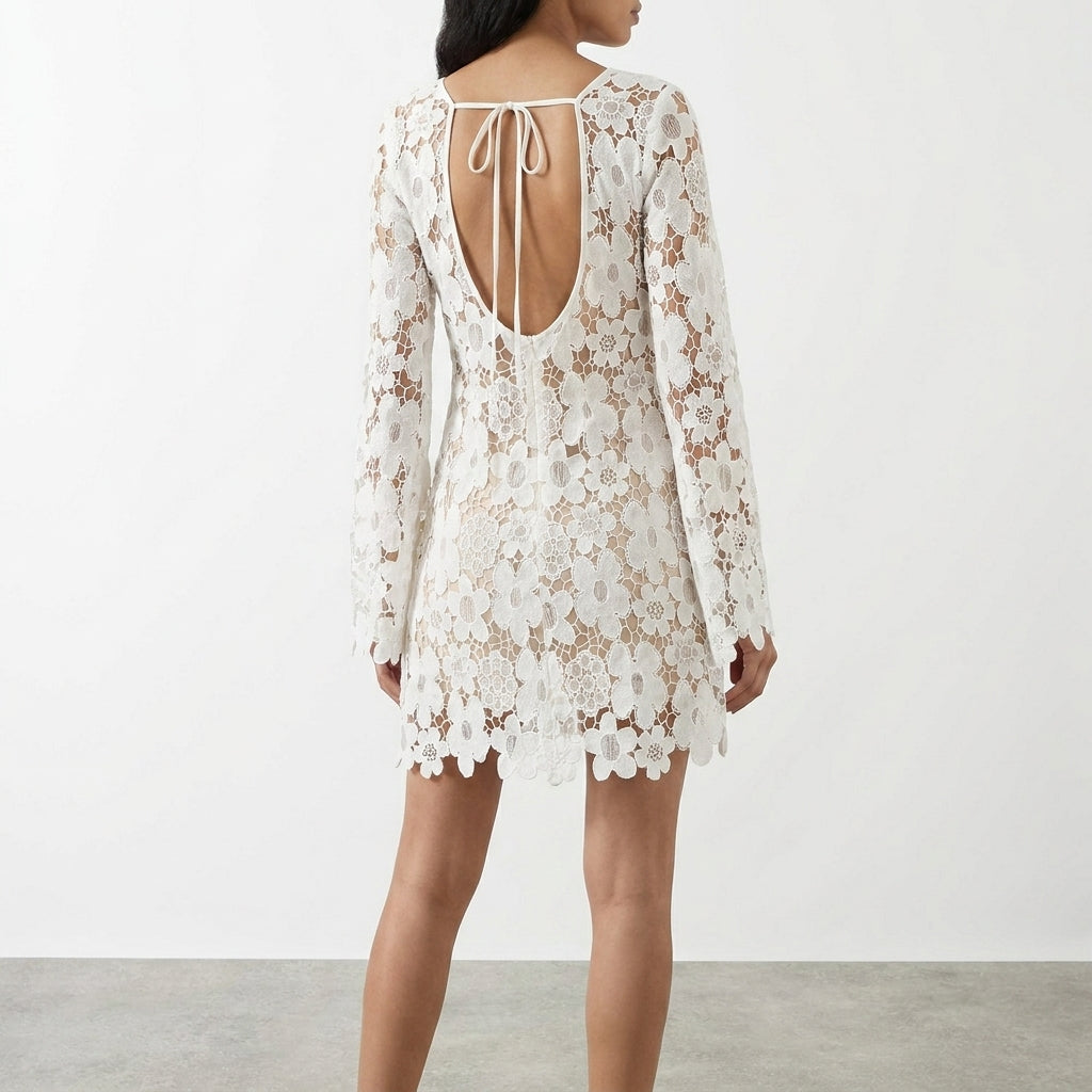 Woman in a white lace dress with open back, bow tie.