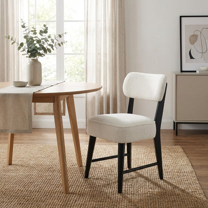 Modern chair with white cushion and dark wooden legs.