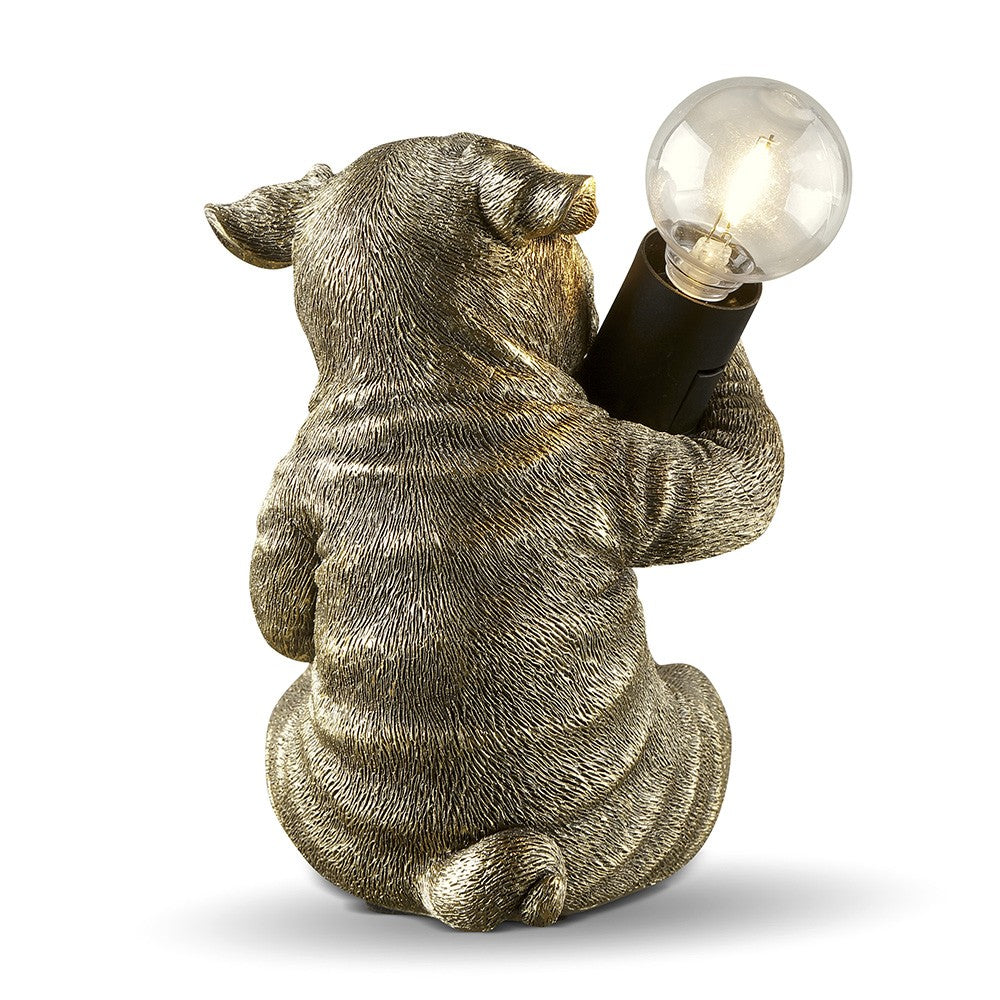Pig-shaped lamp holding a glowing bulb.