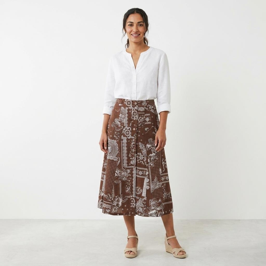 Woman wearing a patterned brown skirt and tan platform heels.