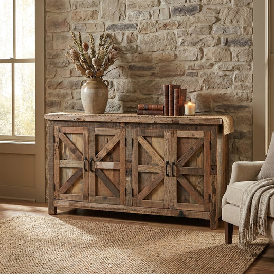 Rustic room with stone wall, wooden sideboard, vase, books, and a candle.