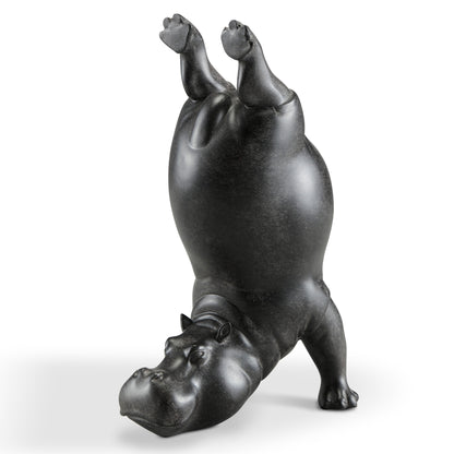 Black hippo statue doing a handstand.
