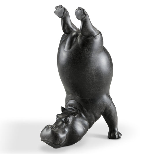 Black hippo statue doing a handstand.