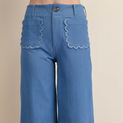 Blue pants with scalloped pocket edges and button detail.