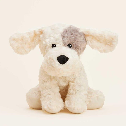 Fluffy plush dog with beige fur and a gray patch over one eye.