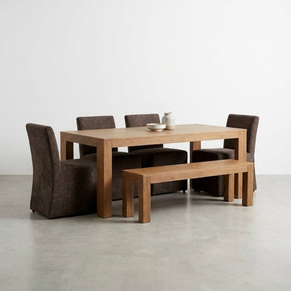 Wooden dining table set with chairs and bench on a minimalist floor.