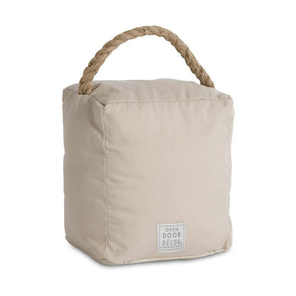 Beige fabric doorstop with rope handle and label.