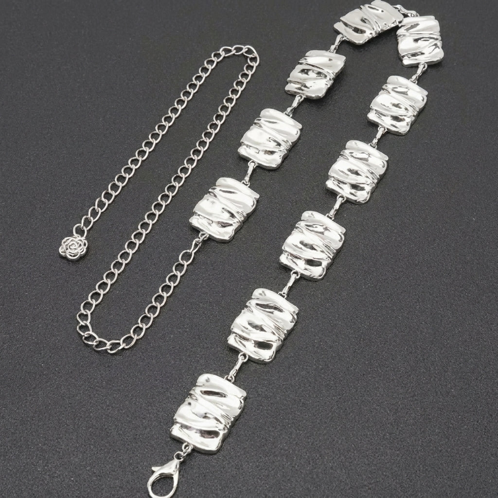 Silver chain and bracelet with textured square links on a dark background.
