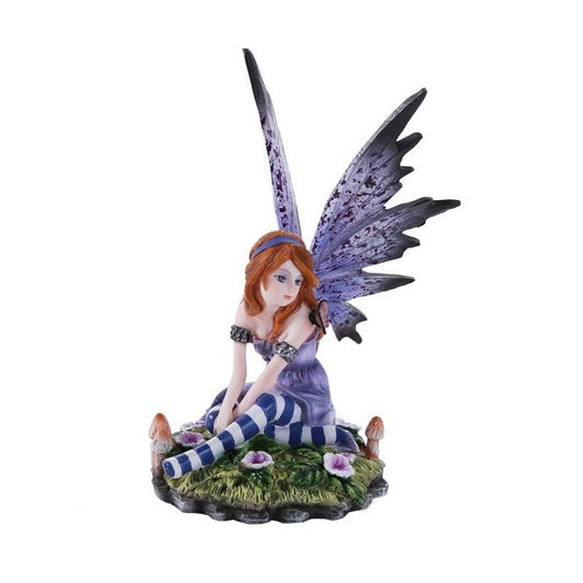 Fairy figurine with purple wings, sitting on grass with striped stockings.