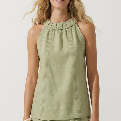 Woman in a sleeveless, light green top with ruffled neckline.