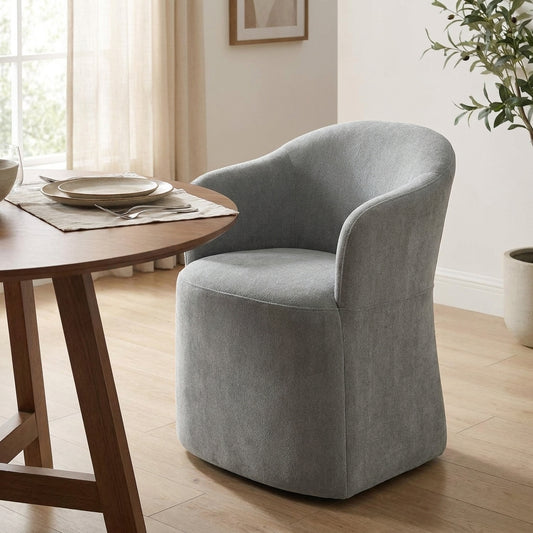 Gray upholstered chair by a wooden dining table in a bright room.