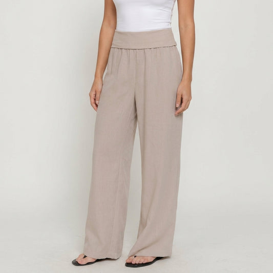 Woman in beige wide-leg pants and white top.