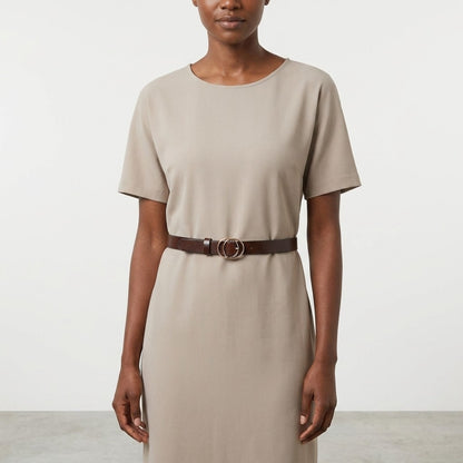 Woman in beige dress with a brown belt.