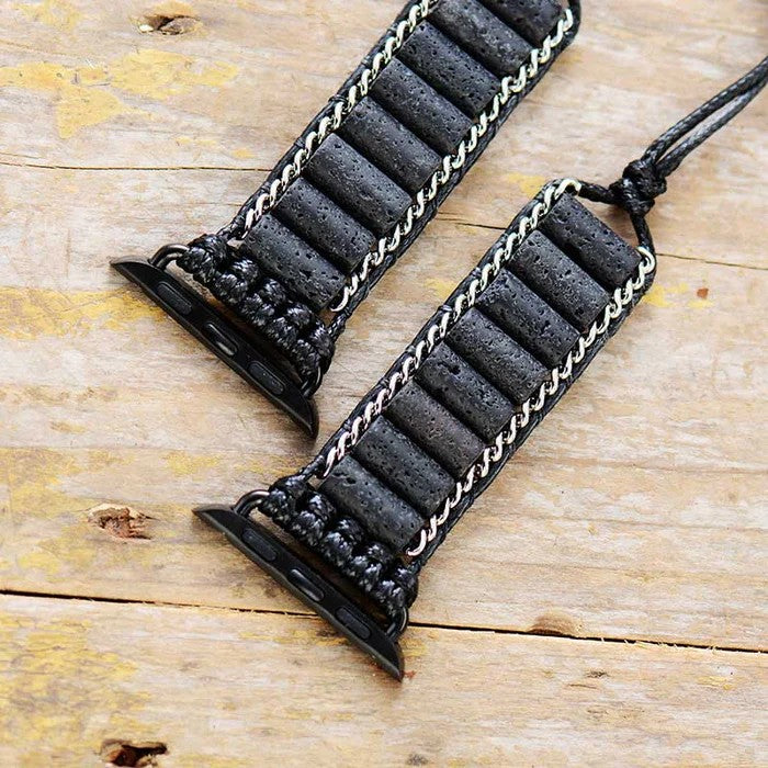 Black leather Apple Watch straps on wooden surface.