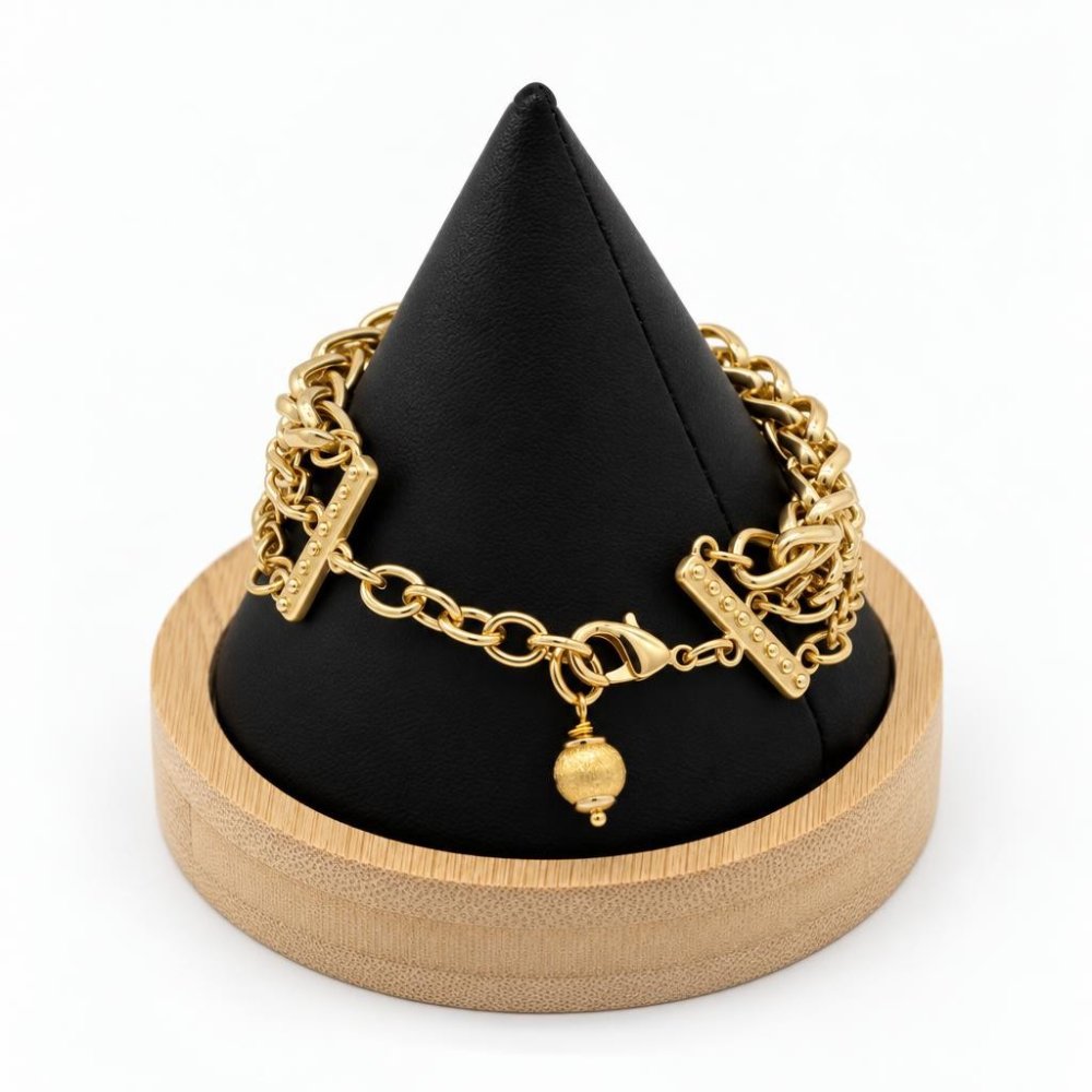 A gold charm bracelet displayed on a black cone-shaped stand atop a wooden base.
