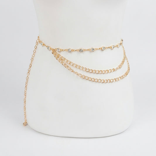 Gold chain belt with rhinestone detailing on a white mannequin.