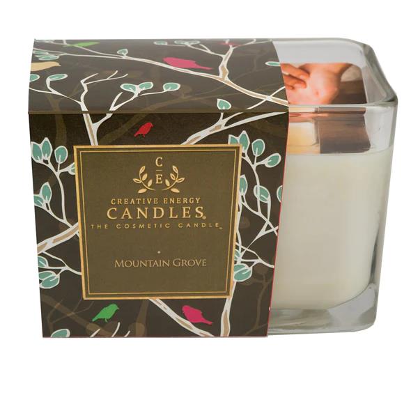 Decorative candle in a square glass, packaged in a leafy floral box design.