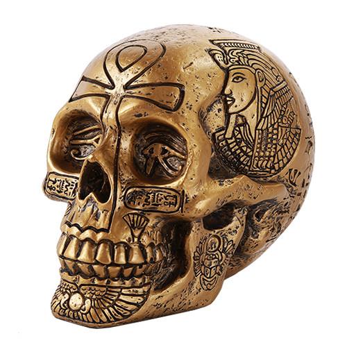 Golden skull with Egyptian hieroglyphs and a pharaoh engraving.