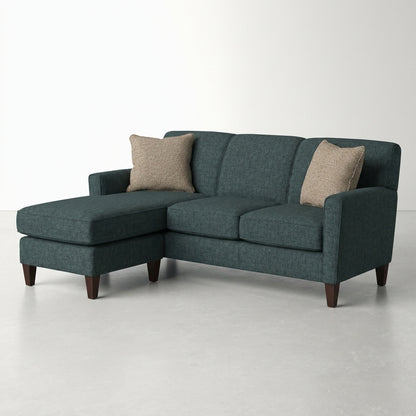 Dark gray sectional sofa with two beige pillows.