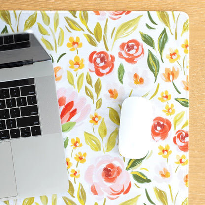 Laptop and mouse on floral mat.