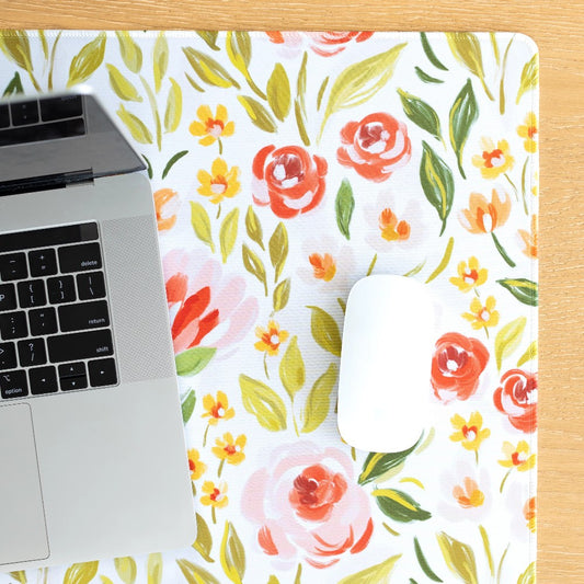 Laptop and mouse on floral mat.