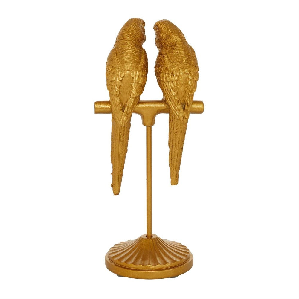 Two golden parrot sculptures on a stand.