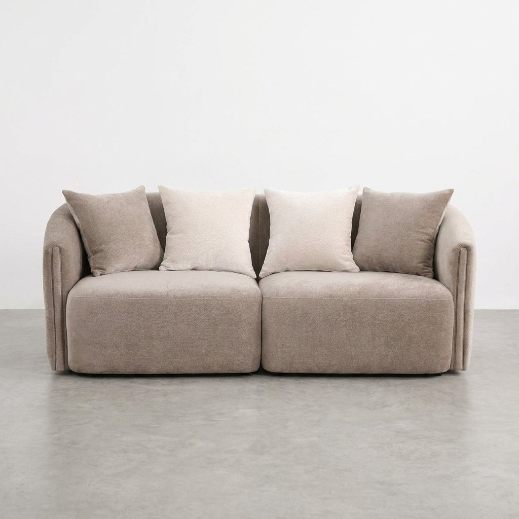 Side view of a beige sofa with cushions.