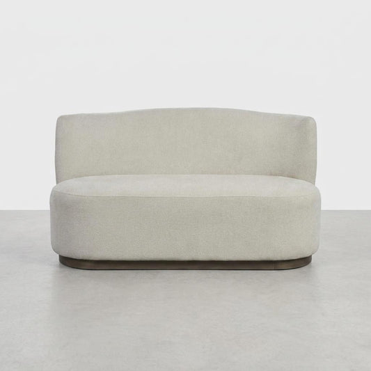 Minimalist beige loveseat on a gray floor.