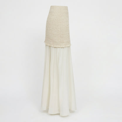Elegant two-piece dress with textured top and flowing white skirt.