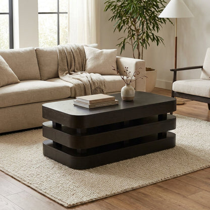 Modern dark wood layered coffee table with rounded edges.