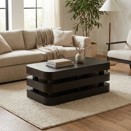 Modern dark wood layered coffee table with rounded edges.