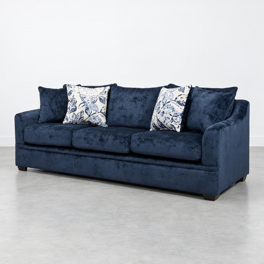 Two dark blue sofas with floral pillows on a gray floor.