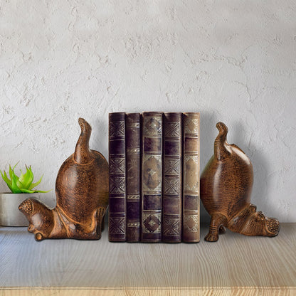 Books between playful bear bookends, beside a small green plant.