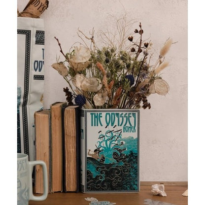 Books and dried flowers in a vase shaped like "The Odyssey."