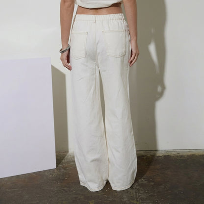Person in white wide-leg pants, seen from the back.