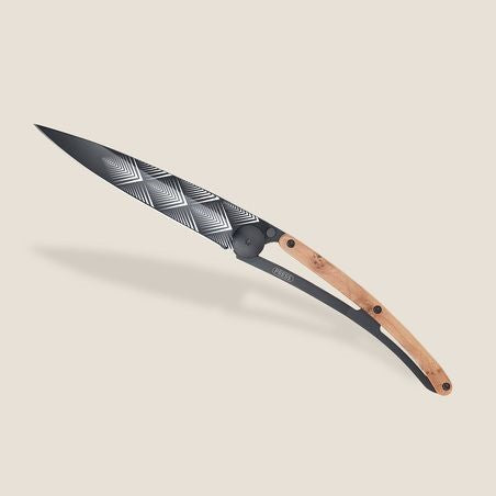 Elegant folding knife with patterned blade and wood handle on a neutral background.