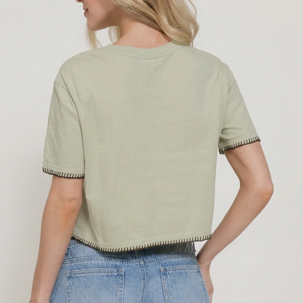 Person in a beige crop top and jeans, facing away.