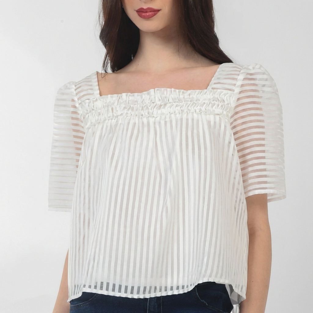 Woman wearing a white striped blouse with square neckline.