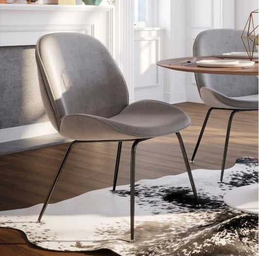 Gray chair with thin legs on a cowhide rug in a modern room.